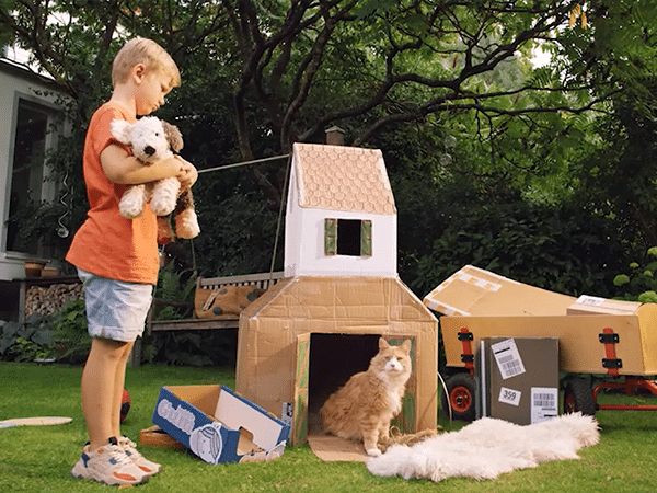Vorschaubild des Sappi-Films: Junge mit Kuscheltier, Kartonhaus und Katze im Garten.